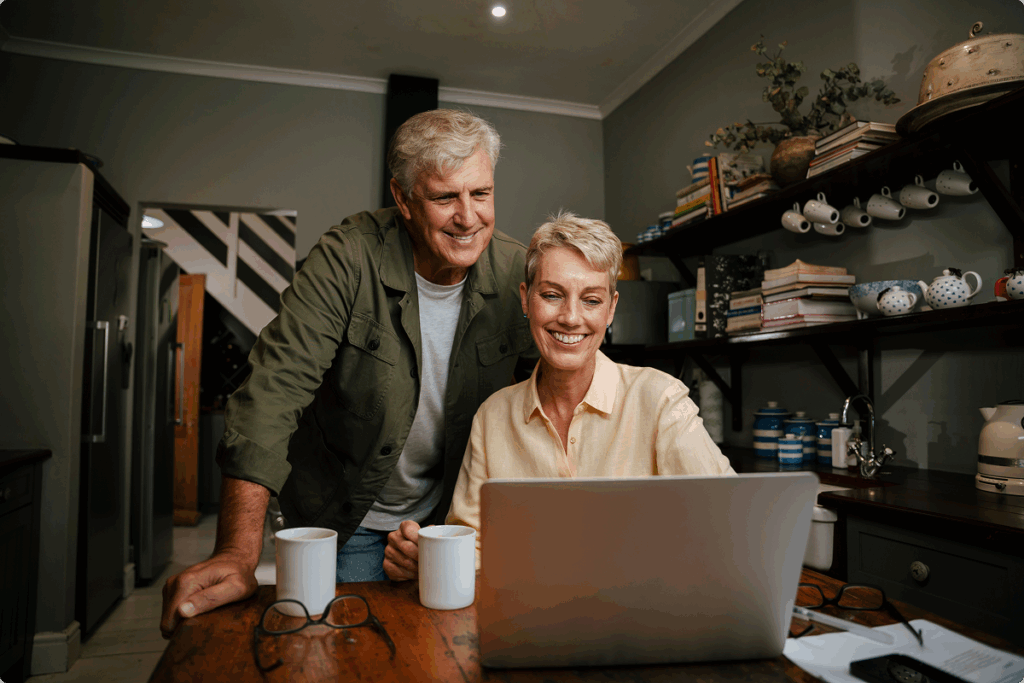 couple smiling and looking at laptop screen